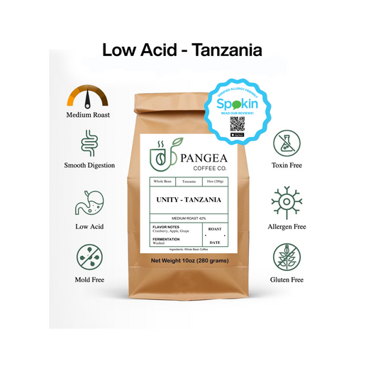A package of Pangea Coffee Co.'s Unity – Tanzania medium roast whole bean coffee, emphasizing its low acid content and other quality attributes like smooth digestion, medium roast, and toxin-free.
