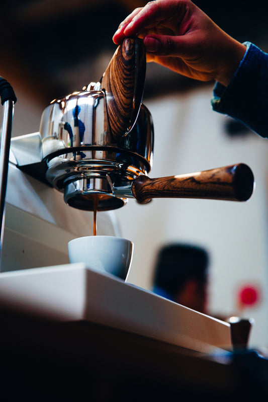 Barista pulling low acid espresso shot on professional espresso machine